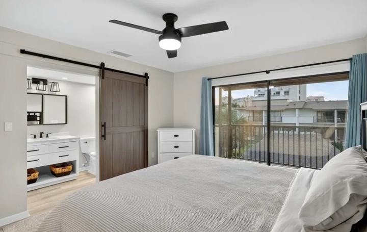 Primary bedroom barn door leading to the en-suite bathroom of the Marco Island monthly rental