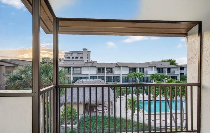 Screened balcony view over the tiki hut and community pool at the Marco Island rental