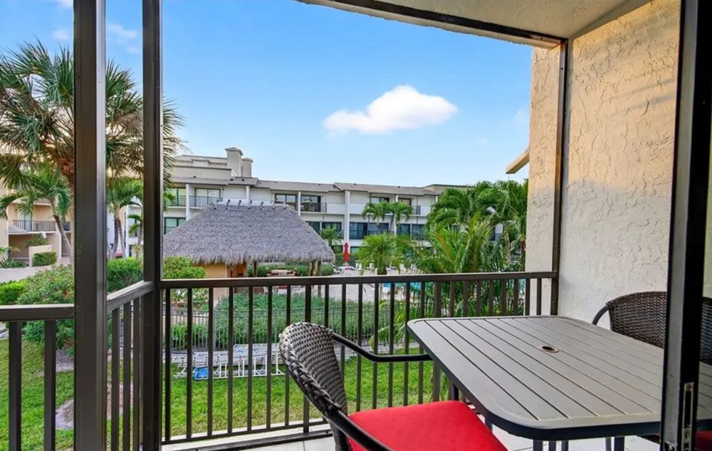 Screened lanai overlooking palms and the community pool at the Marco Island long term rental